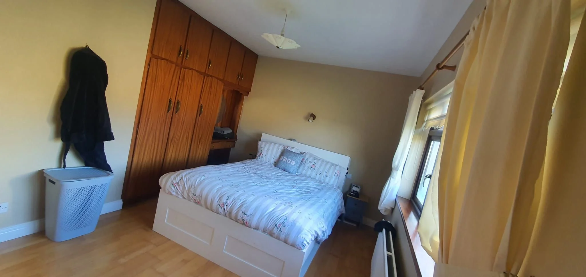 Before view of the bedroom showing the original furniture placement, wall colour, and room layout.