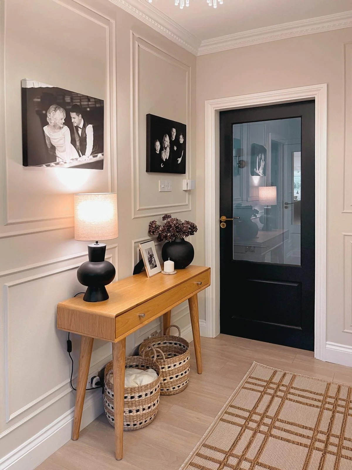 Entryway styling detail with classic panelling, a timber console table, and a softly layered welcoming feel.