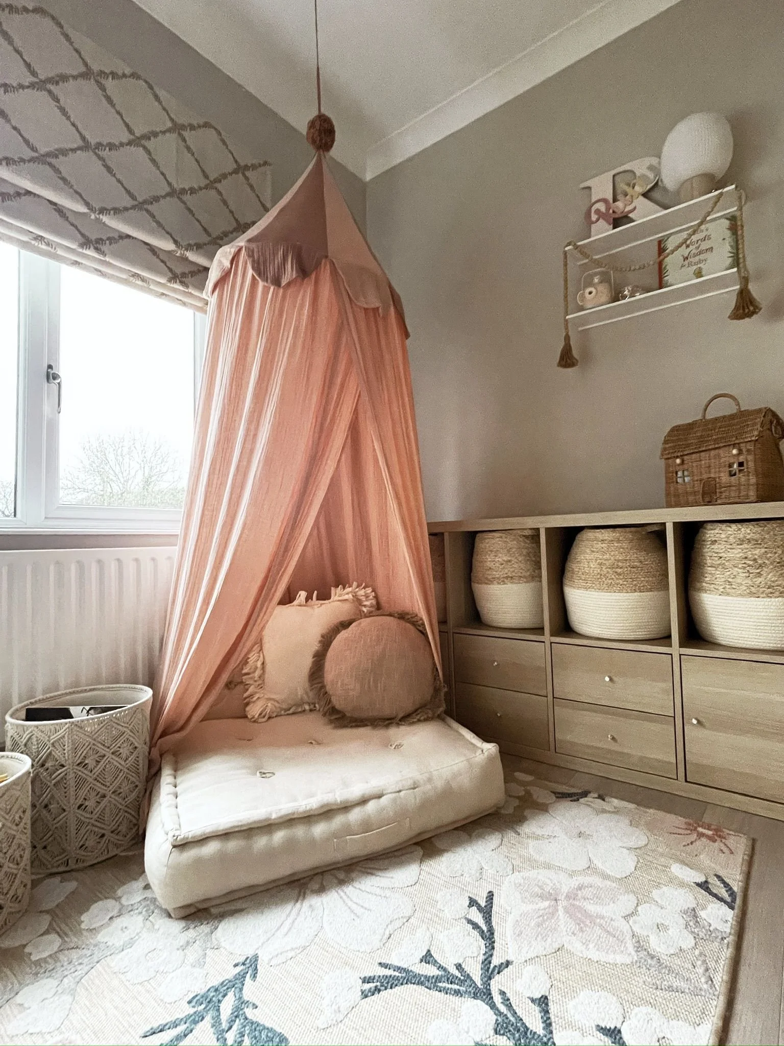 
Children’s reading corner with a draped canopy, soft seating, and a warm, imaginative feel.