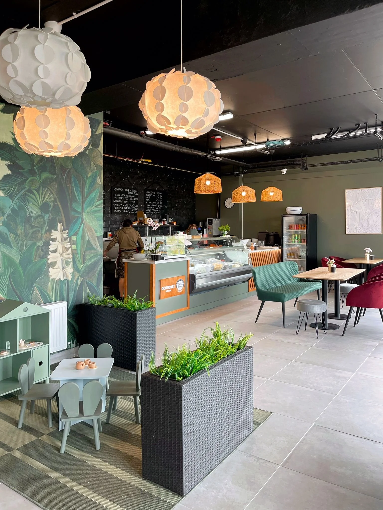 Main dining and lounge area with statement mural wallpaper, rich upholstery, and a relaxed contemporary feel.