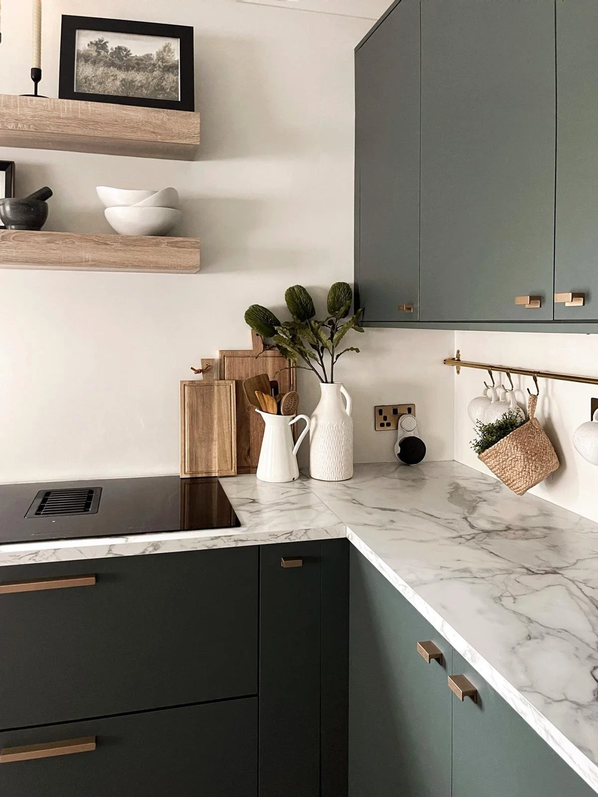 Kitchen styling detail with marble-effect surfaces, warm metallic accents, and softly layered everyday styling.