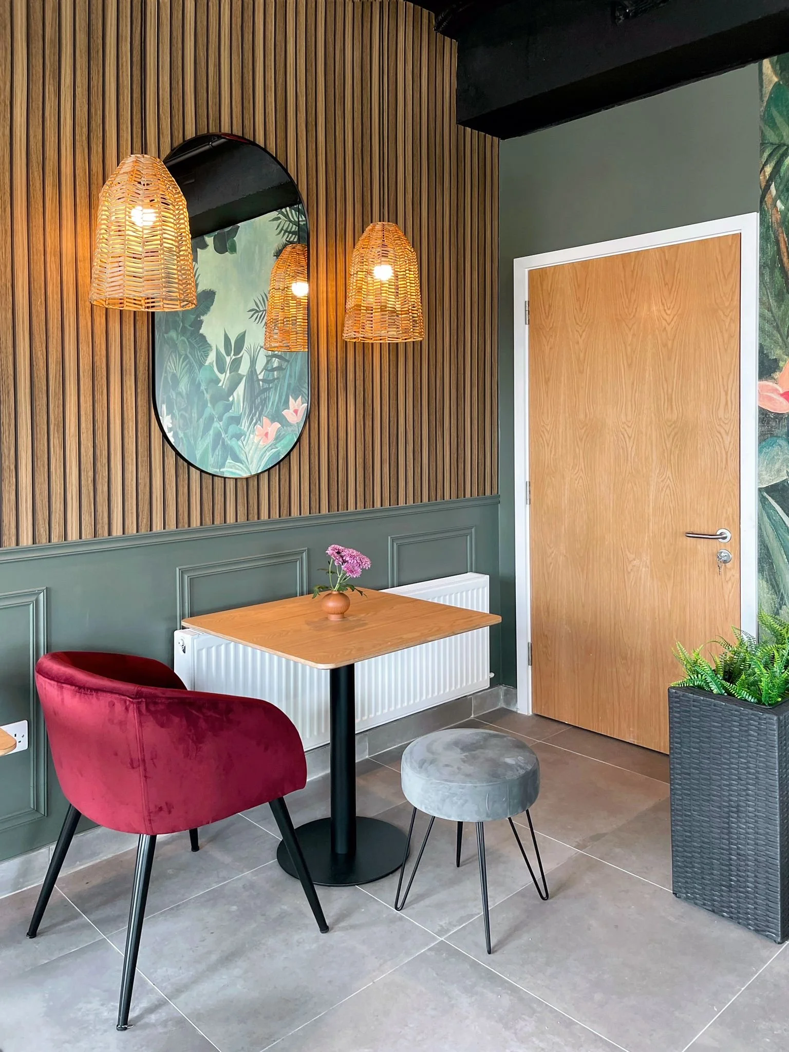 Close-up of decorative pendant lighting, round mirrors, timber slat wall, and compact dining setting.