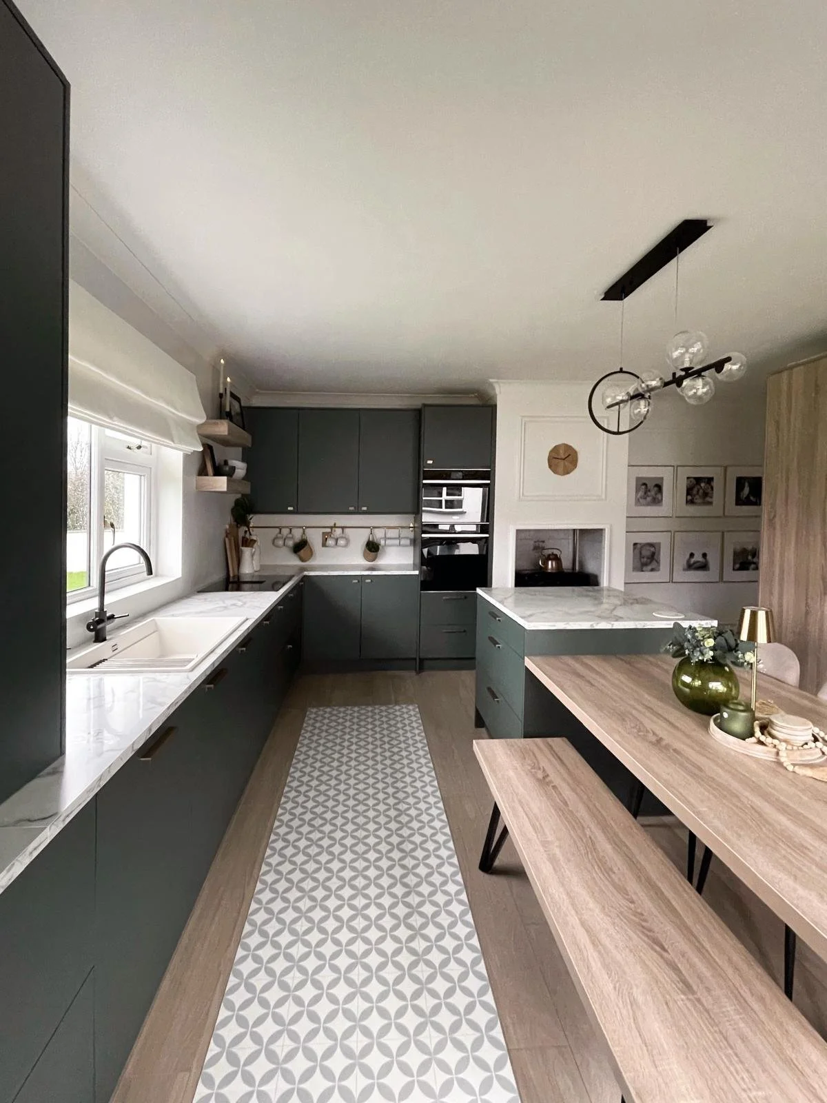 Kitchen detail with deep-toned cabinetry, marble-effect worktops, and warm natural styling for a softer, more refined everyday feel.