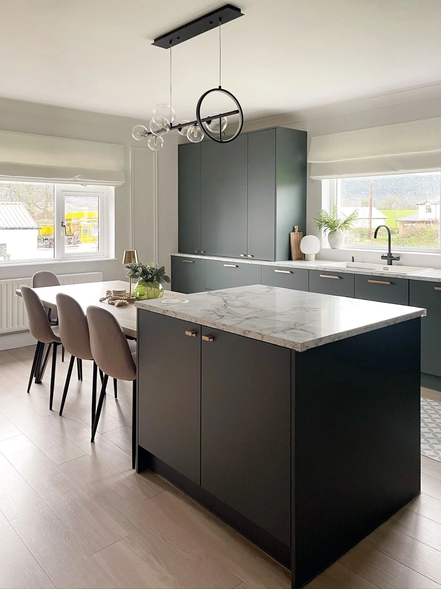 Kitchen and dining space with an island, soft neutral seating, and a more connected open-plan feel.