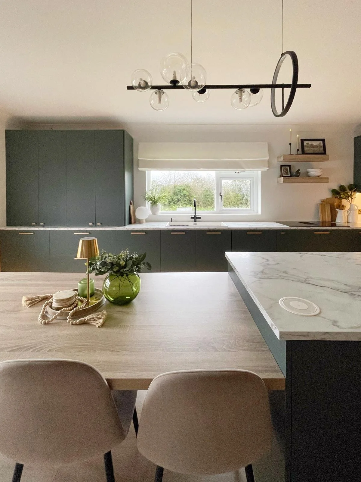 Kitchen and dining space with muted cabinetry, a large island, and a calm, family-friendly open-plan layout.