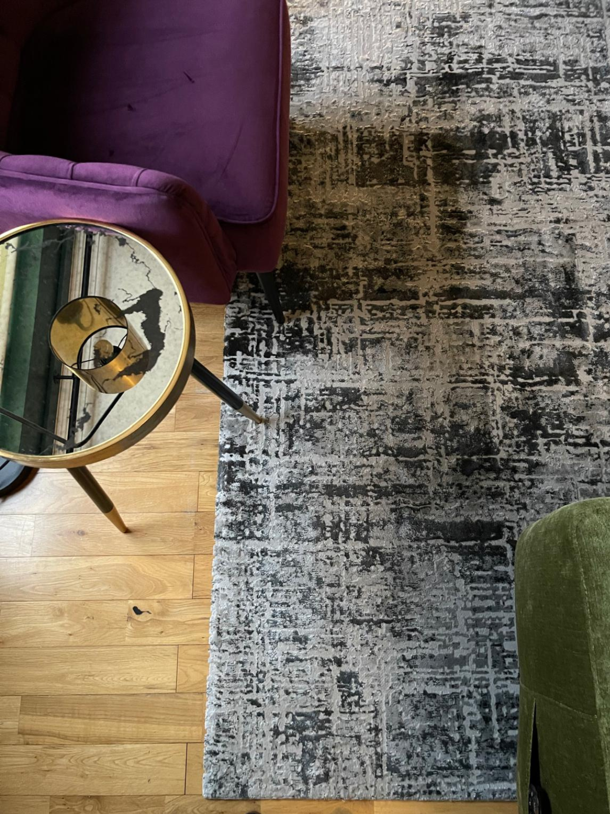 Close-up detail of the rug and accent seating, highlighting the layered textures and richer, more grounded palette.