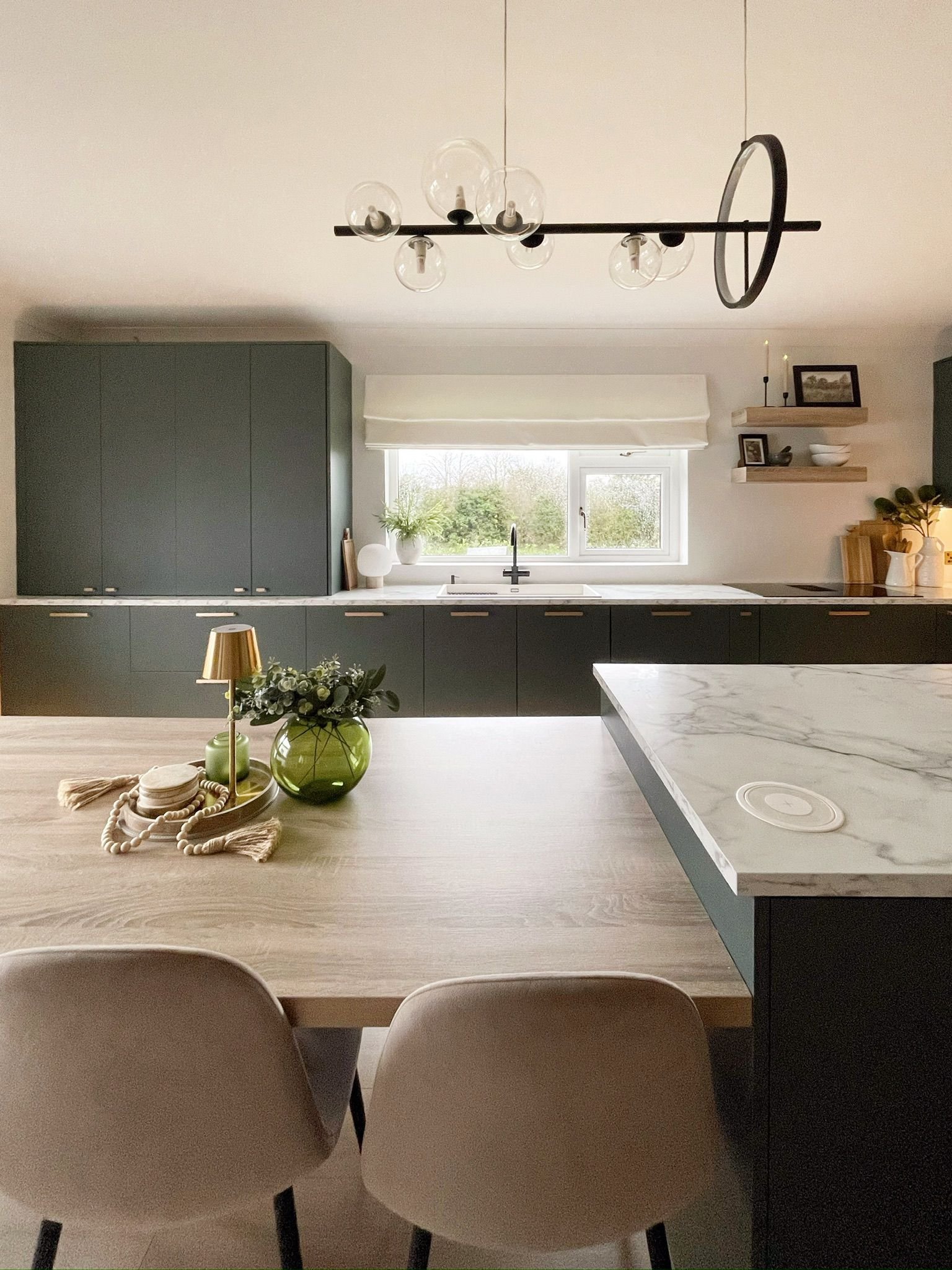 Open-plan kitchen with a central island, muted cabinetry, and a calm, family-friendly layout.