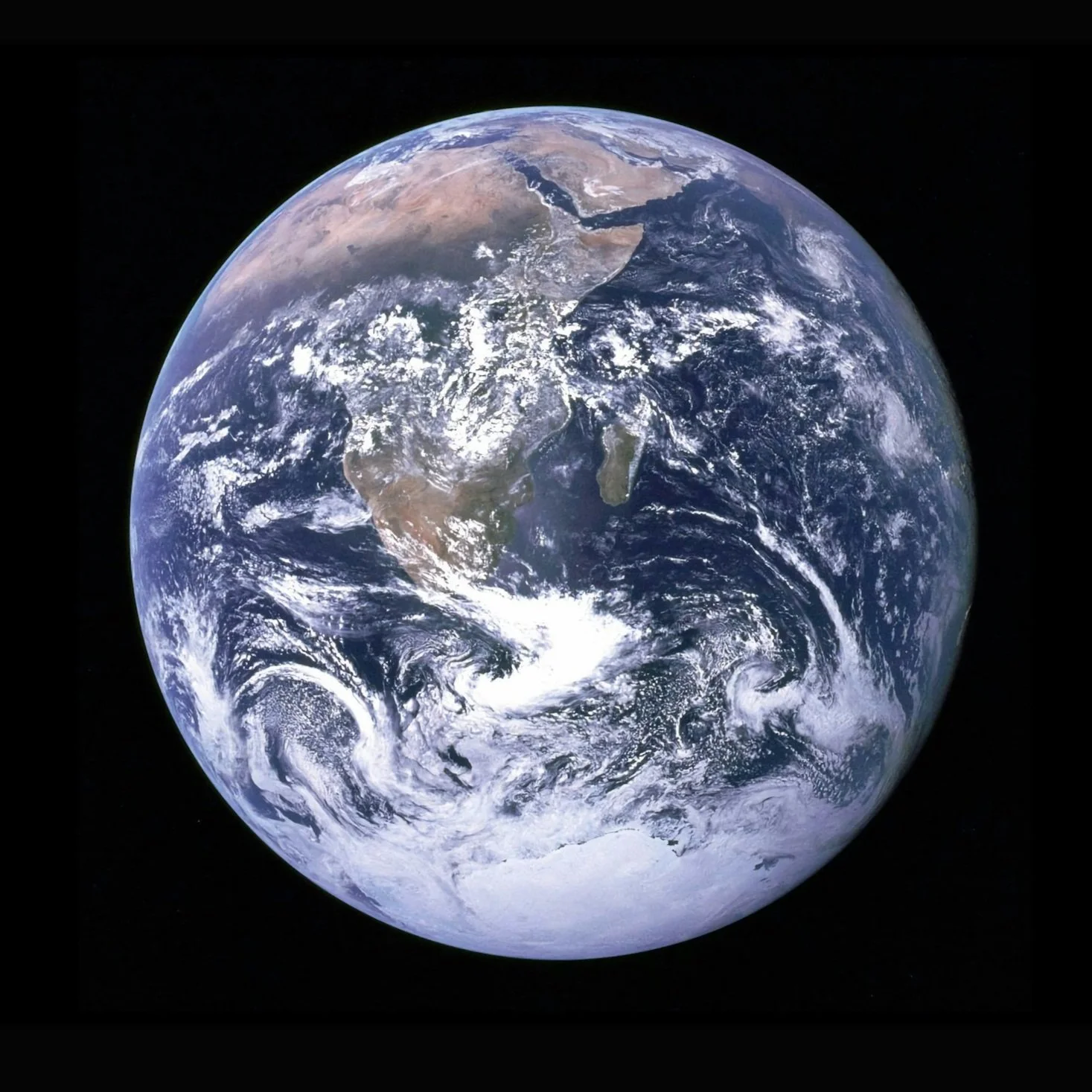 A photograph of Earth from space, showing continents of Africa, Europe, and Asia, with cloud formations and oceans visible.