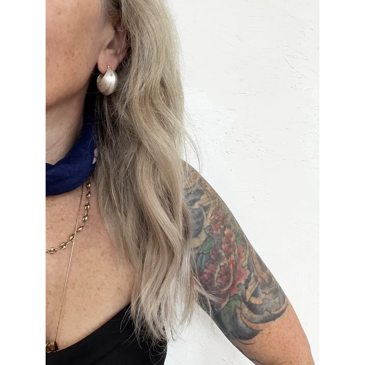 woman with blonde hair and blue neck bandana wearing sterling silver and yellow gold bauble earrings