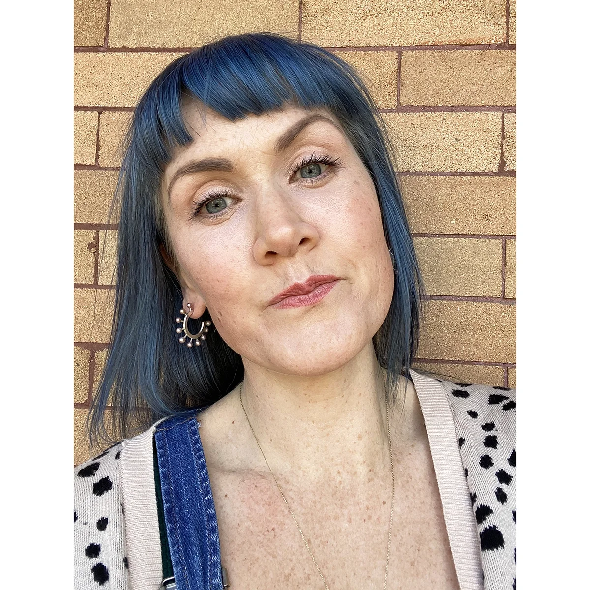 woman with blue hair and leopard cardigan wearling pink freshwater pearl and sterling silver hoop earrings
