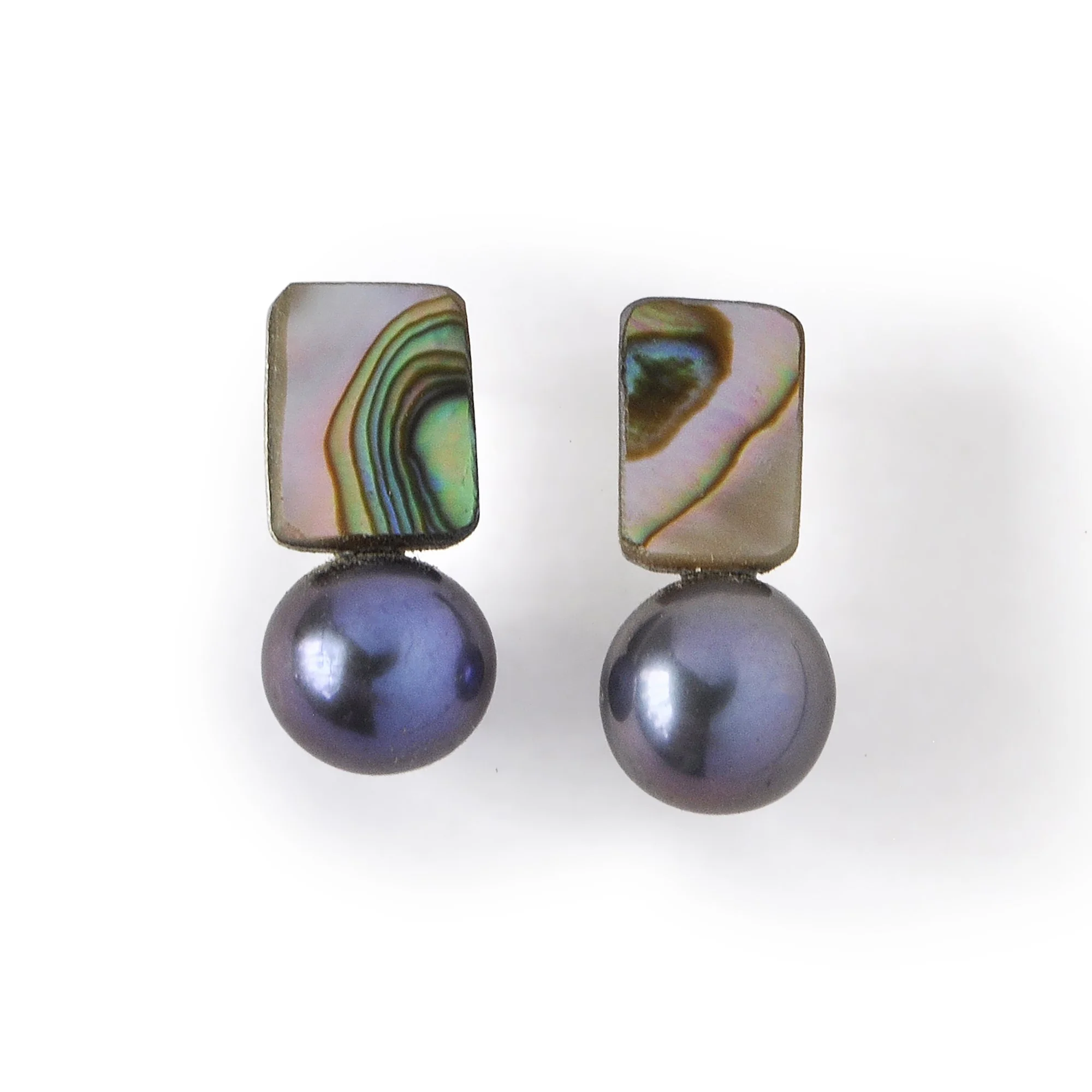 pink, blue, green ann purple waves of iridescent abalone shell next to a shiny dark blue and black freshwater pearl small stud earring