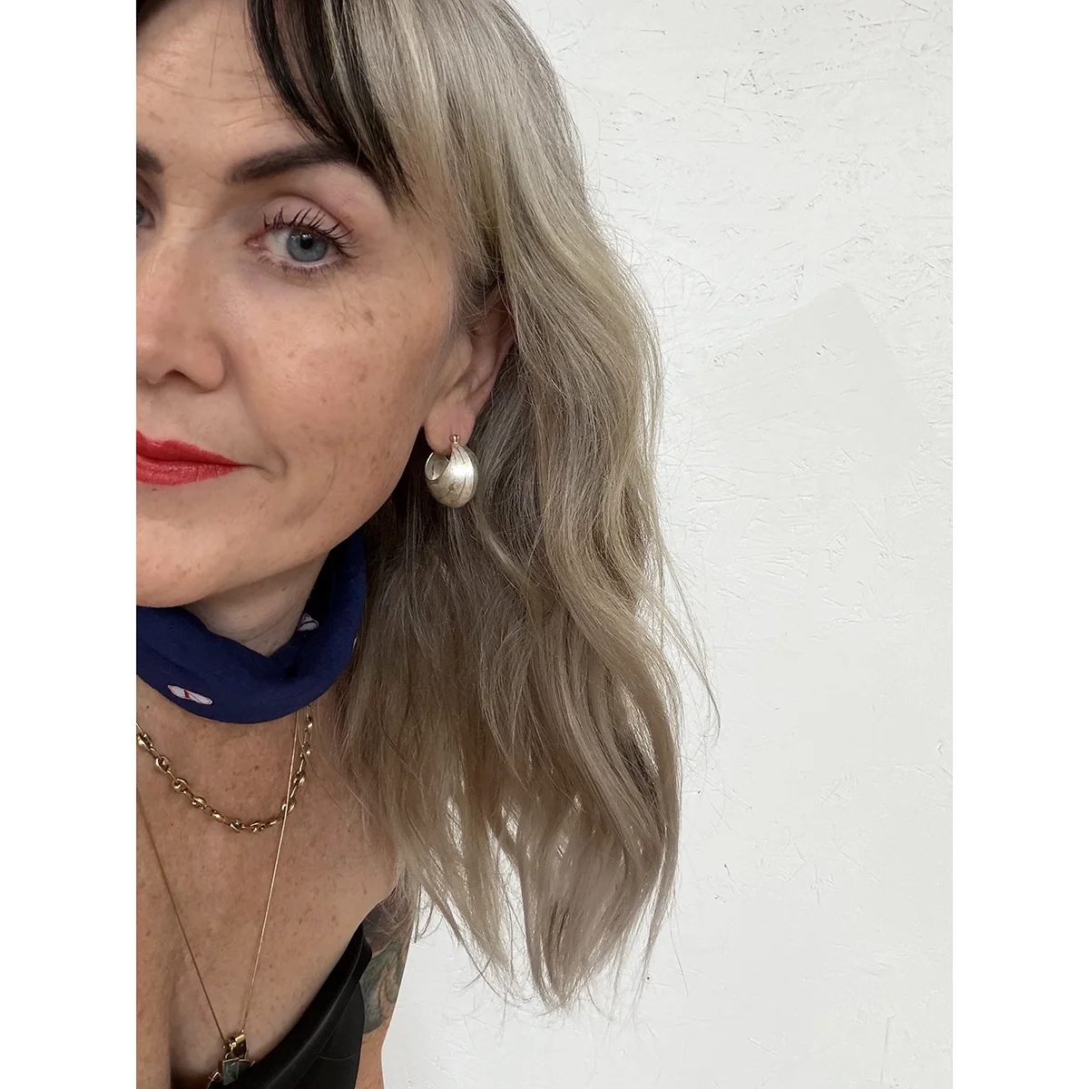 woman with blonde hair and blue neck bandana wearing sterling silver and yellow gold bauble earrings