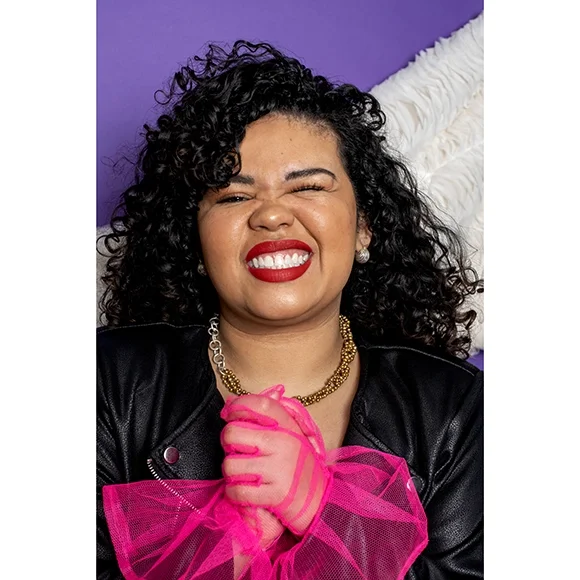 small yellow gold earrings with oxidized sterling silver on a woman with black curly hair, pink sheer gloves and bright red lips with purple and silver shimmer background