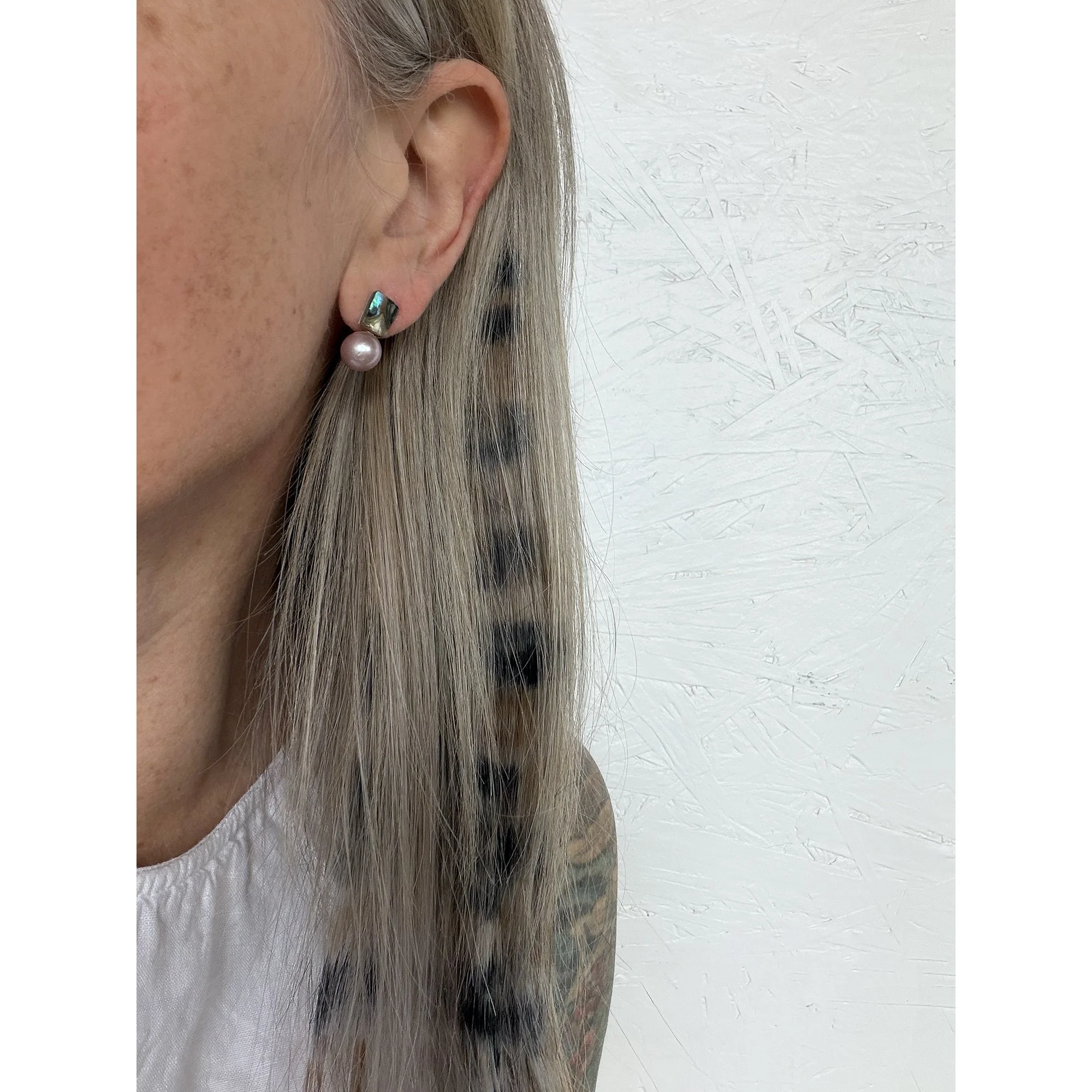small colorful pearl earrings on woman with blonde and black hair & pink lipstick