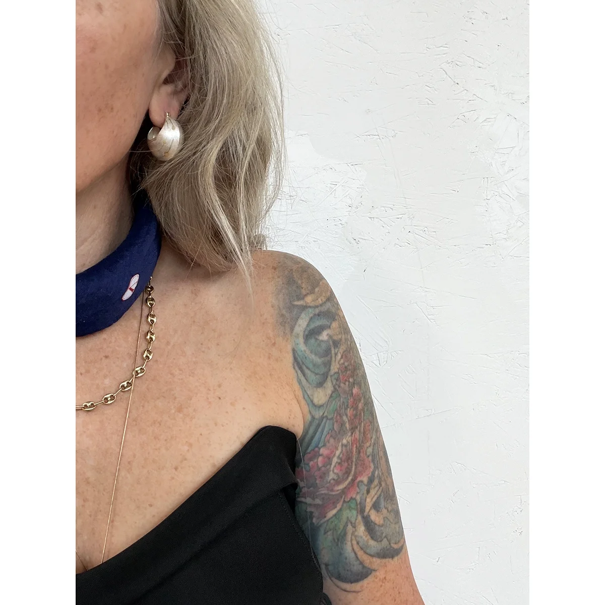 woman with blonde hair and blue neck bandana wearing sterling silver and yellow gold bauble earrings