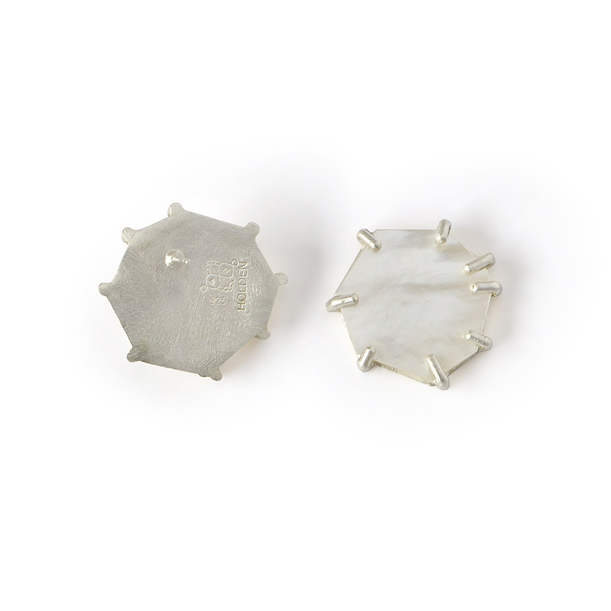 mother of pearl post earrings with one facing backward so ear post is facing forward with artist logo and hallmark stamped into silver