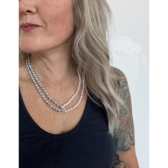 close up of woman with freckles and black tee shirt wearing white and silver freshwater pearl necklace