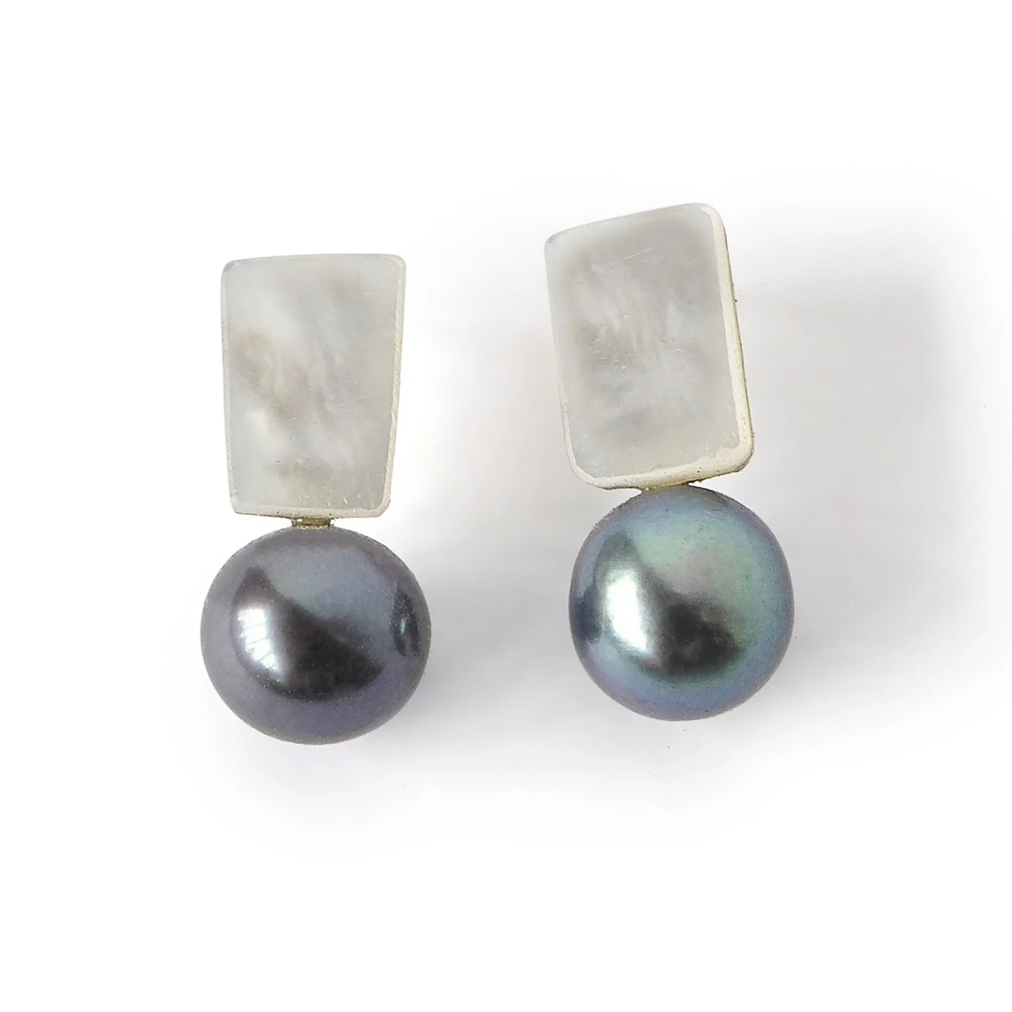 small square of shimmery mother of pearl with a perfect big deep blue black and green pearl
