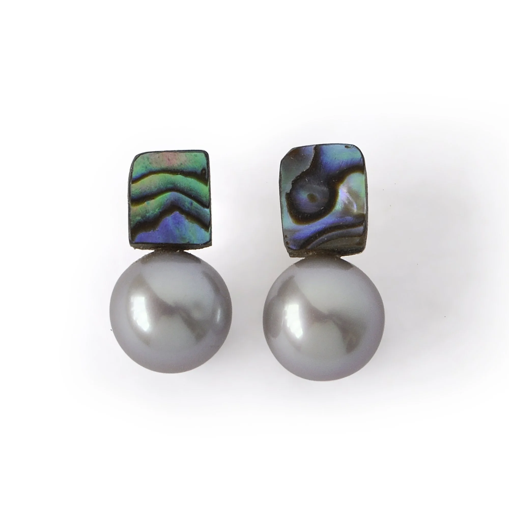 Small abalone shell earrings with waves of blue, green, pink and blue next to a big luscious silver freshwater pearl