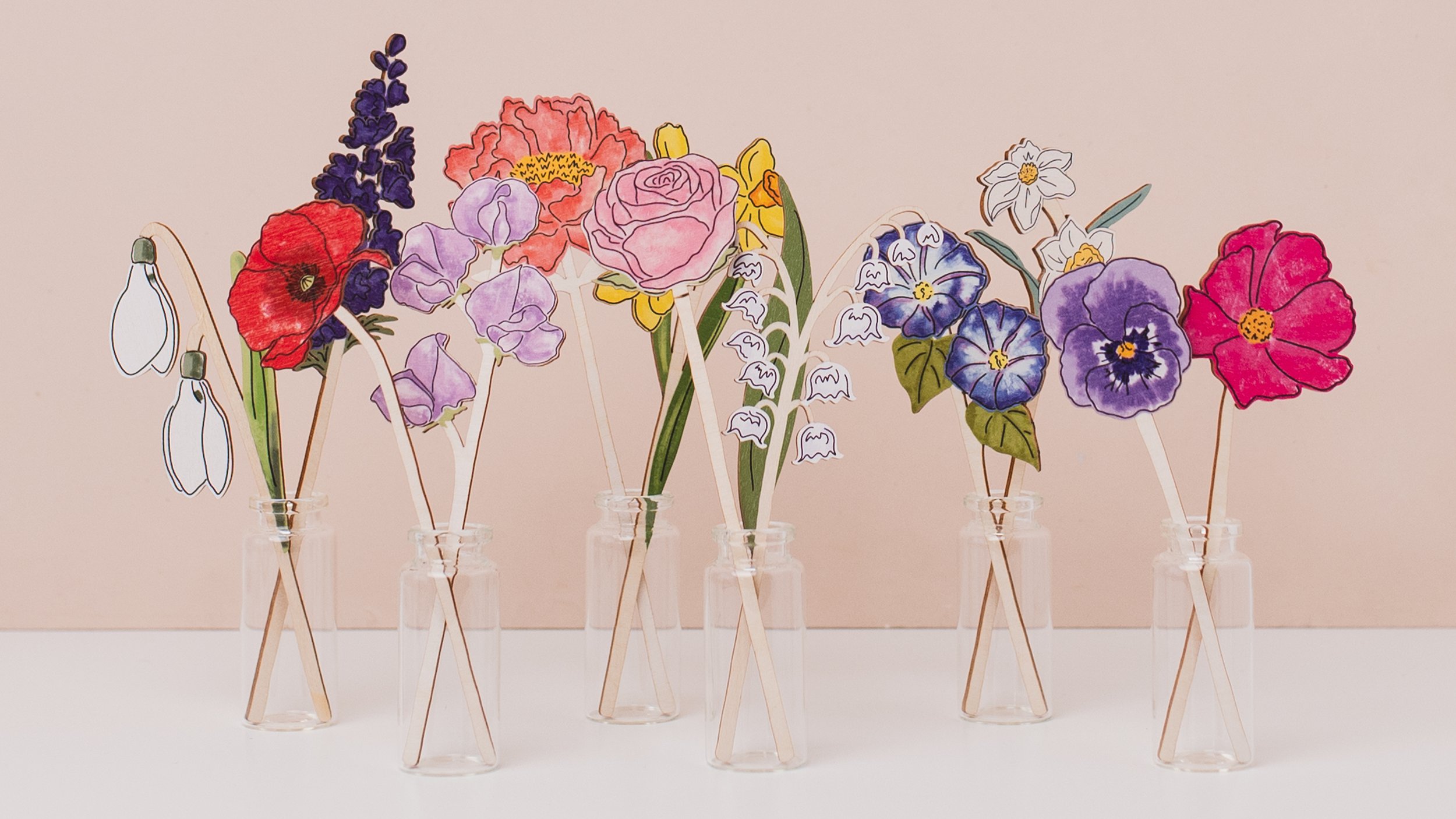 Selection of wooden flowers in vases, displaying all the birth flowers