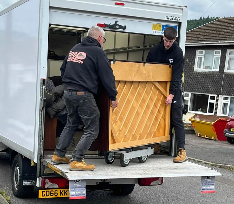 two fine tune piano workers removing a Yamaha piano from a van