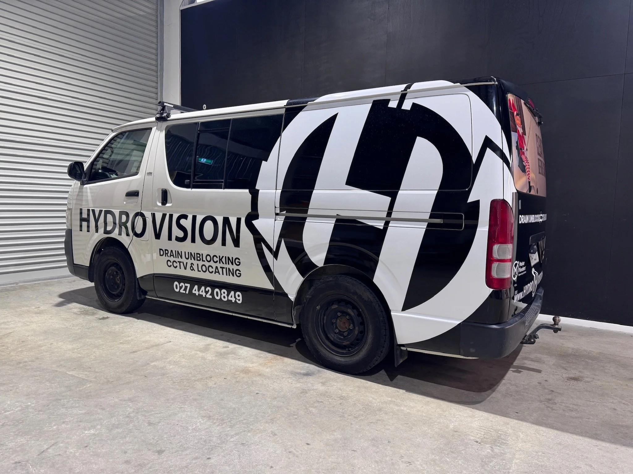 White van with "Hydrovision" branding parked indoors, used for drain unblocking and CCTV services.