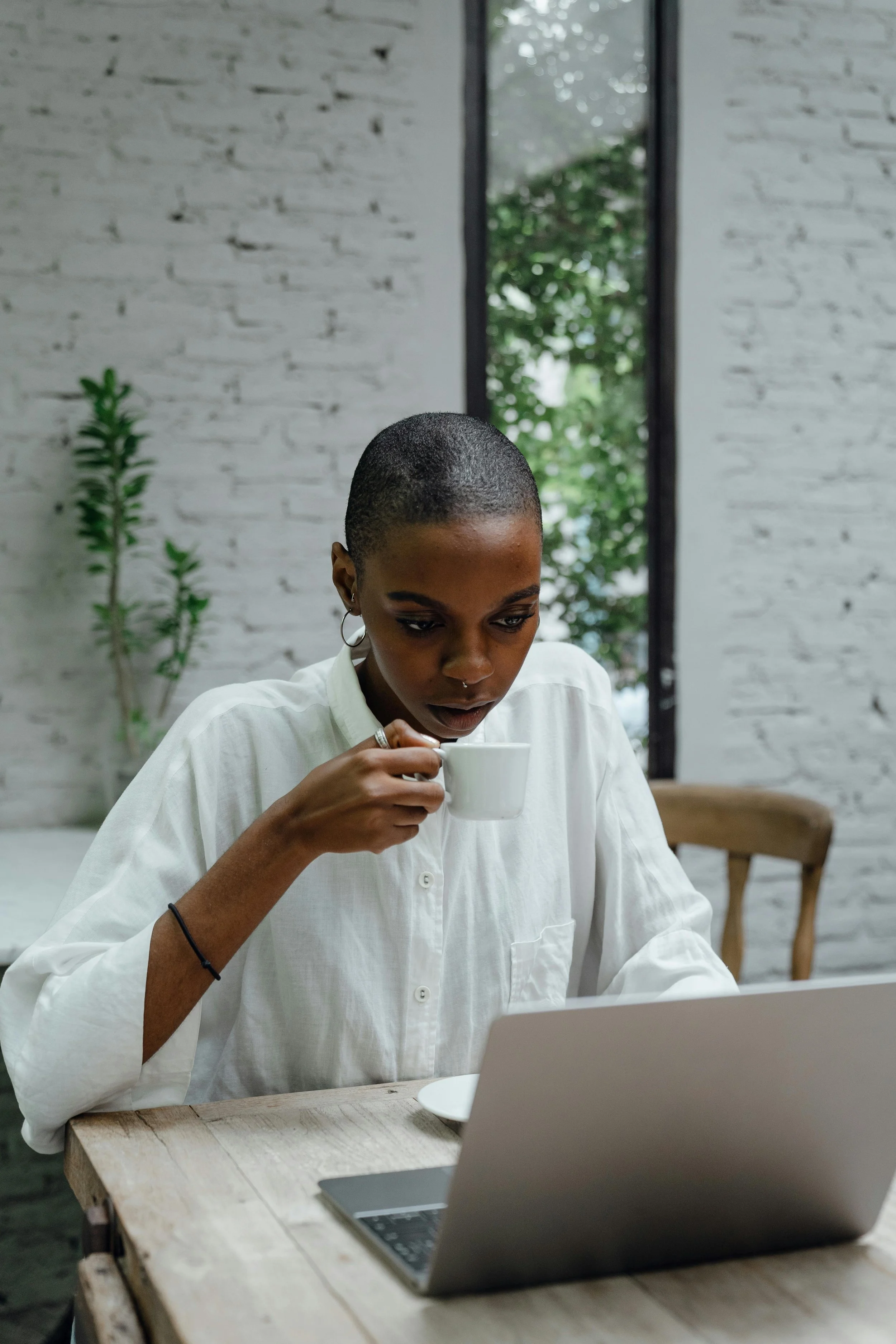 woman drinking coffee, on laptop