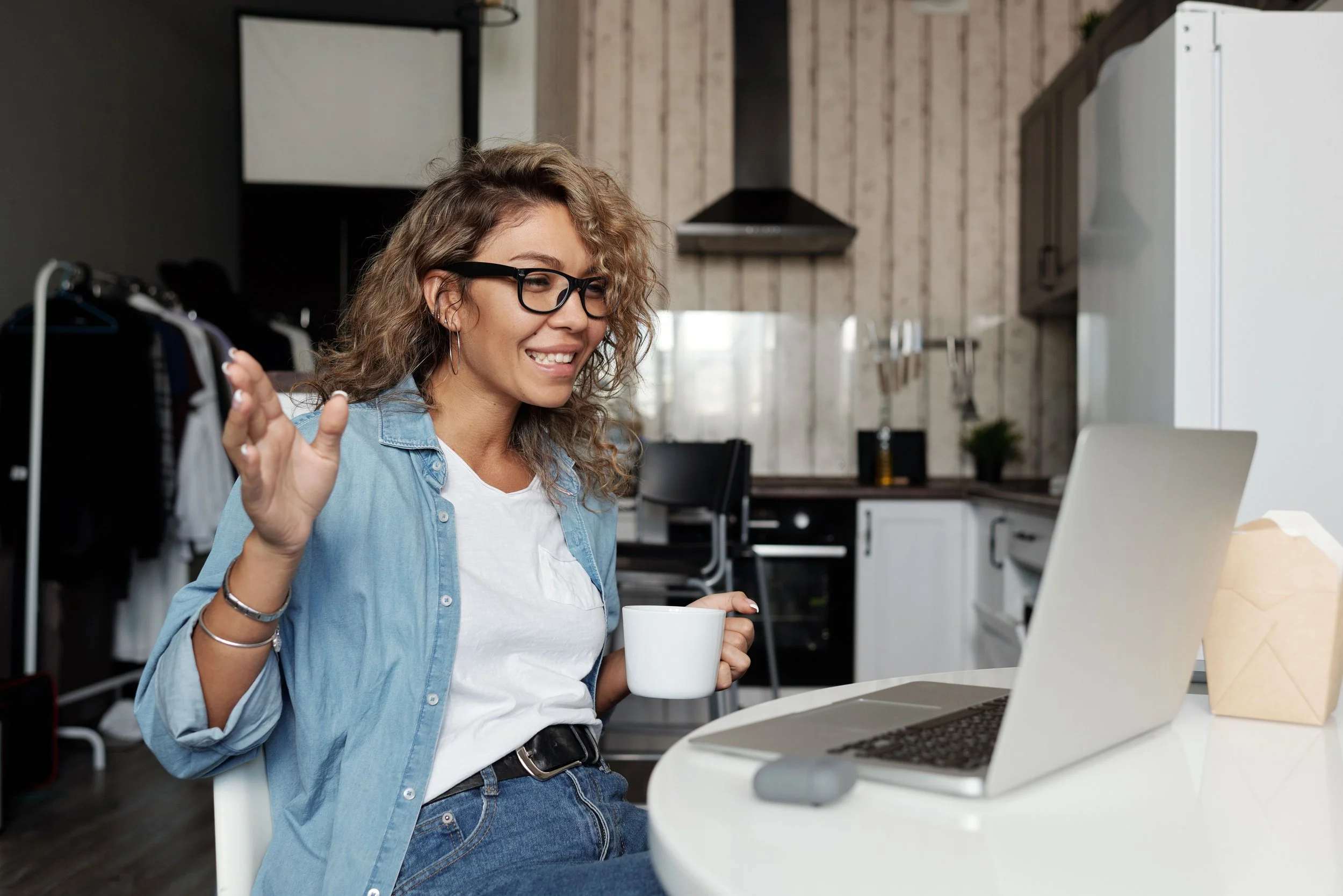 Woman on conference call, drinking coffee.