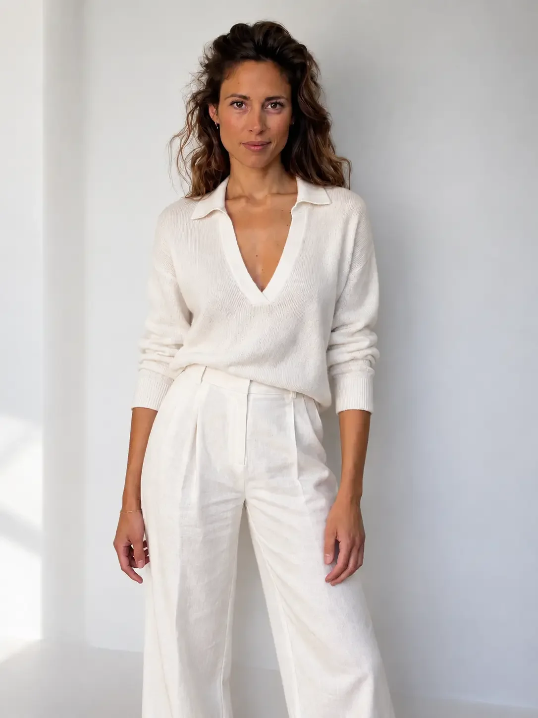 Katerina Tsernou, somatic hypnotherapist and founder of Hypnosomatics, standing in a white studio.