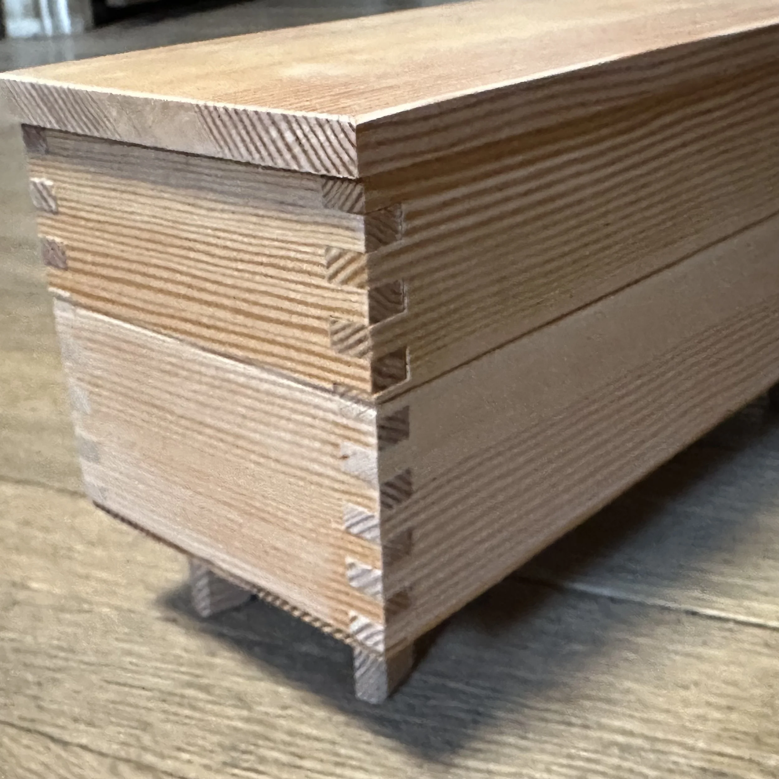 Close-up of a stacked box joint in light-colored wood.