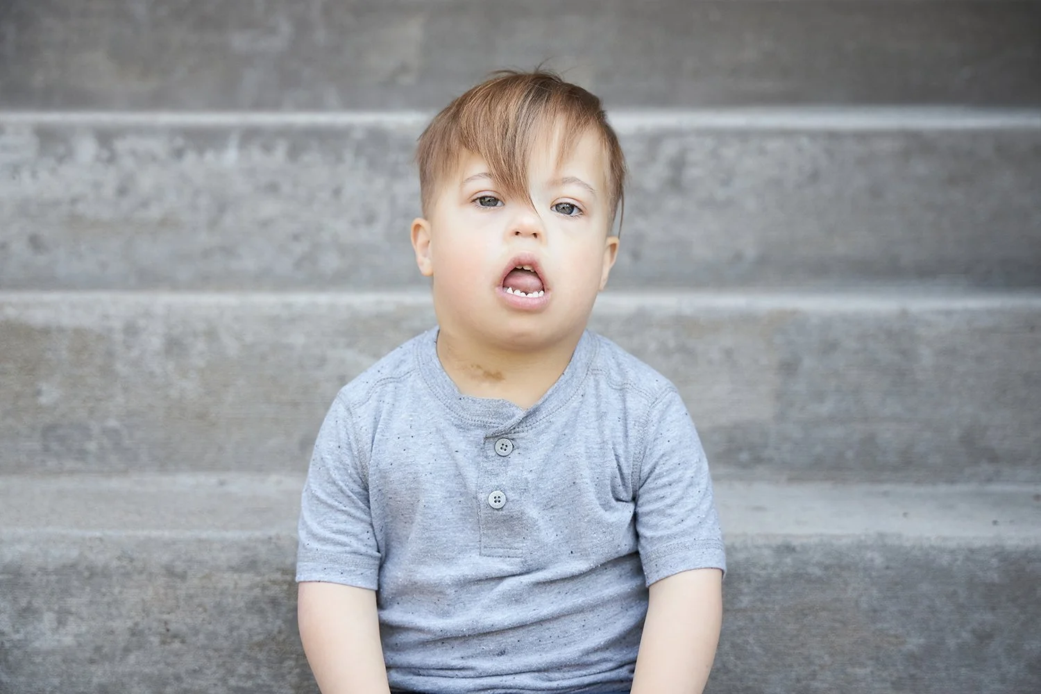 Professional portrait of a young child with Down Syndrome.