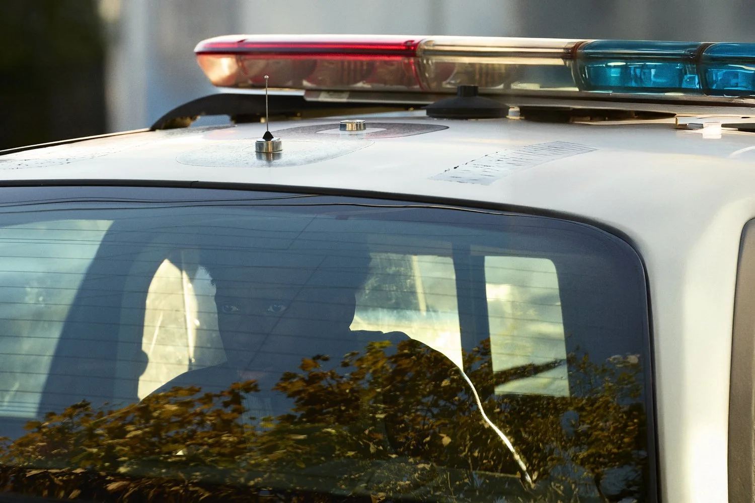 Professional unit still of a young black man, in the back of a police car, for the short film "Now I Lay Me."