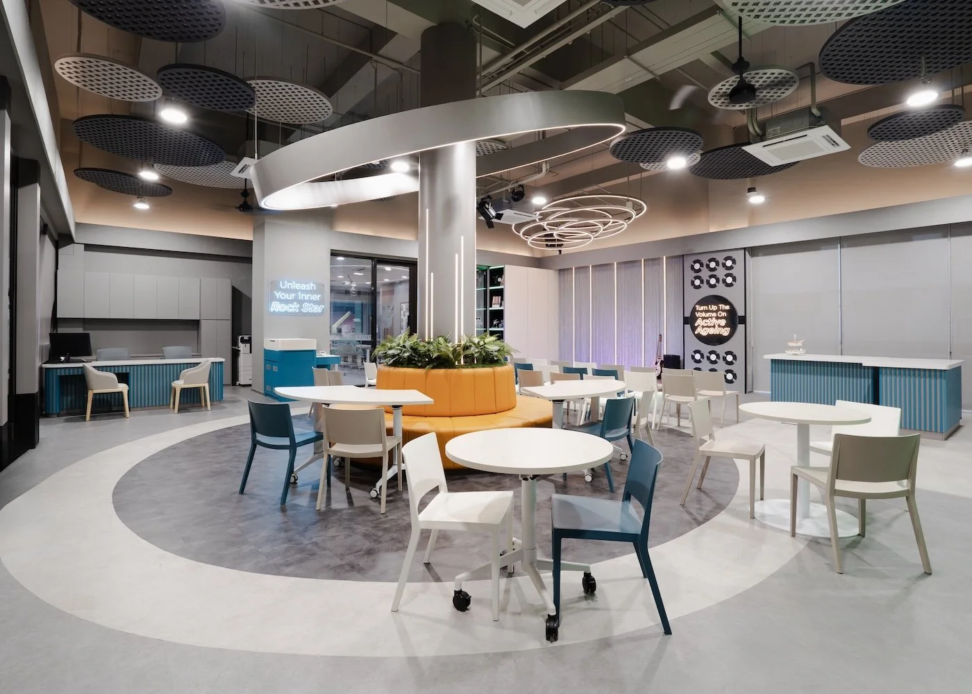 NTUC Health Active Ageing Centre @ Bukit Panjang with cantilevered circular light around pre-existing pillar, dressed up to anchor the space