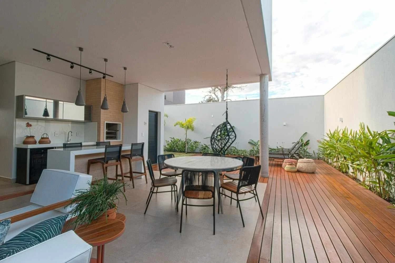 A kitchen patio with wooden floor, plants, and chairs