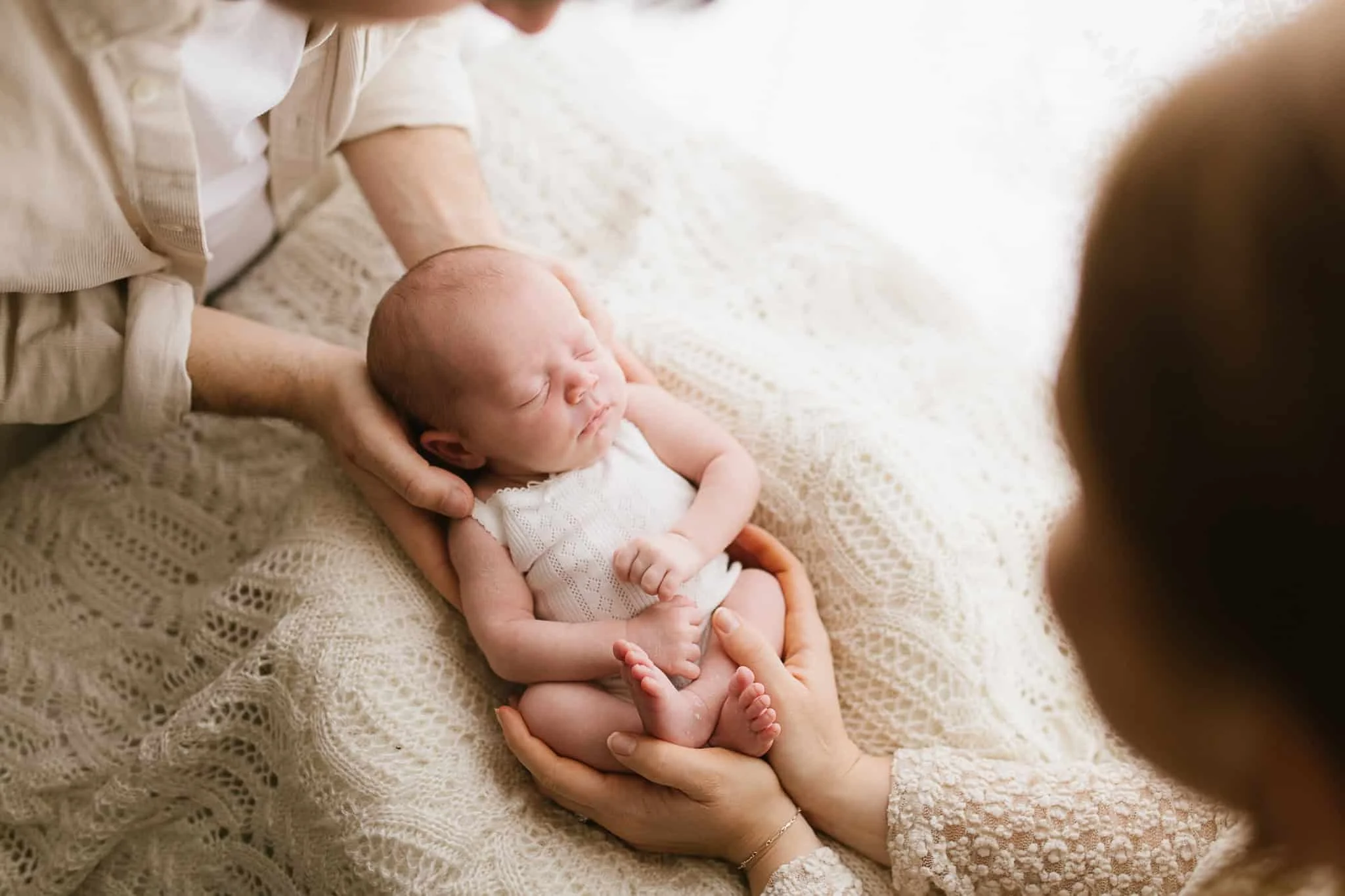 Baby held by parents hands