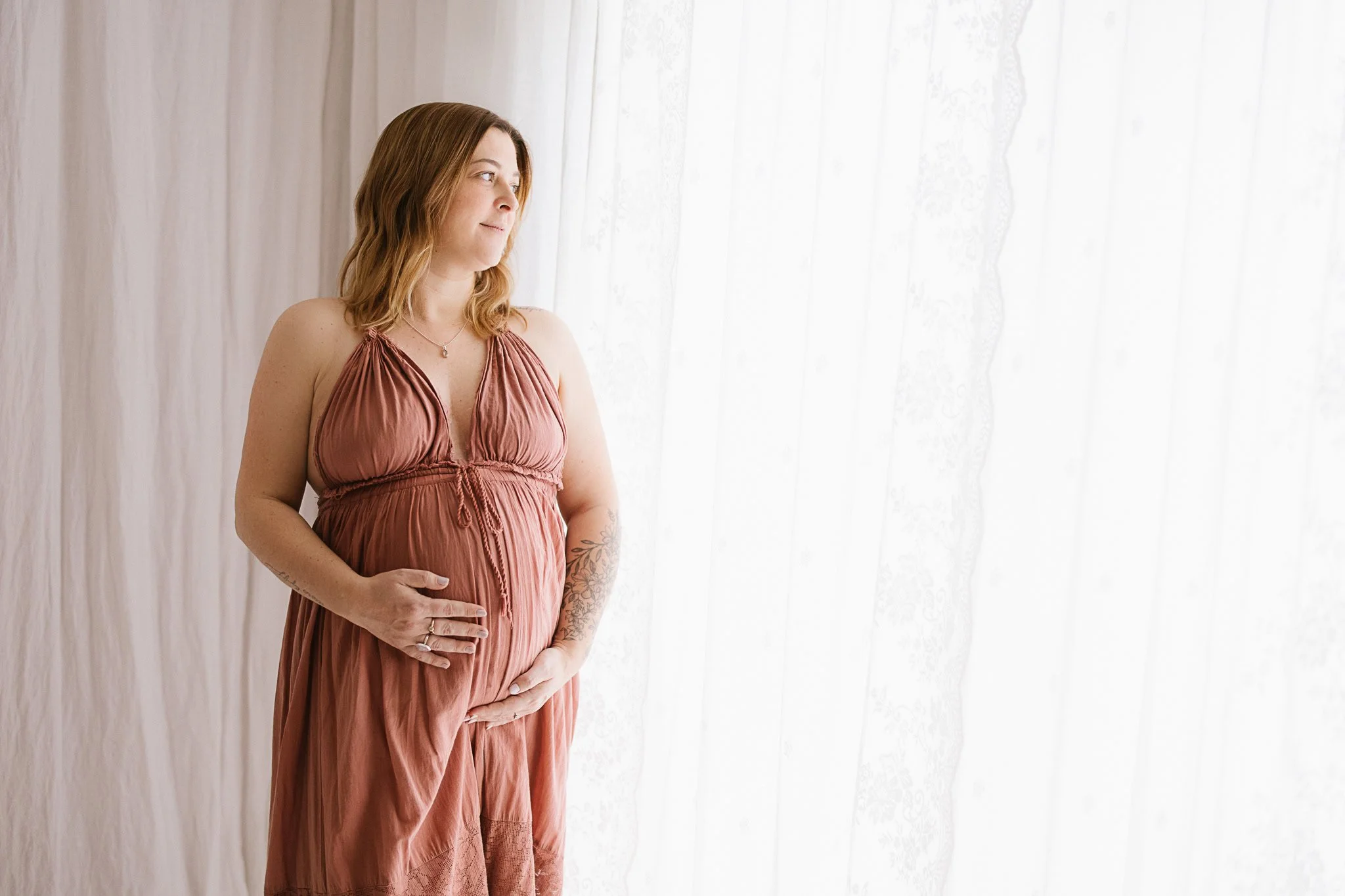 Pregnant woman in pink dress, studio maternity photography Cornwall natural light