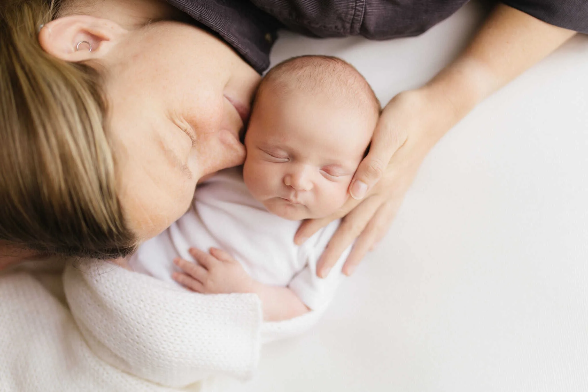 Mother lovingly embraces her 2 week old baby during a heartfelt newborn photoshoot in Cornwall