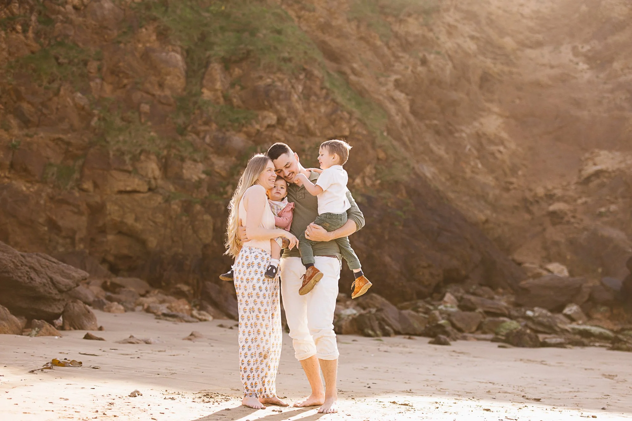 Family of four together on Cornwall beach during family photoshoot