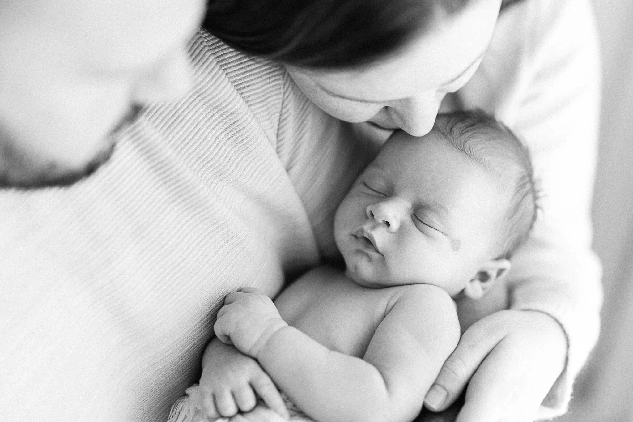 Mother tenderly holding newborn baby, natural lifestyle newborn photography Cornwall