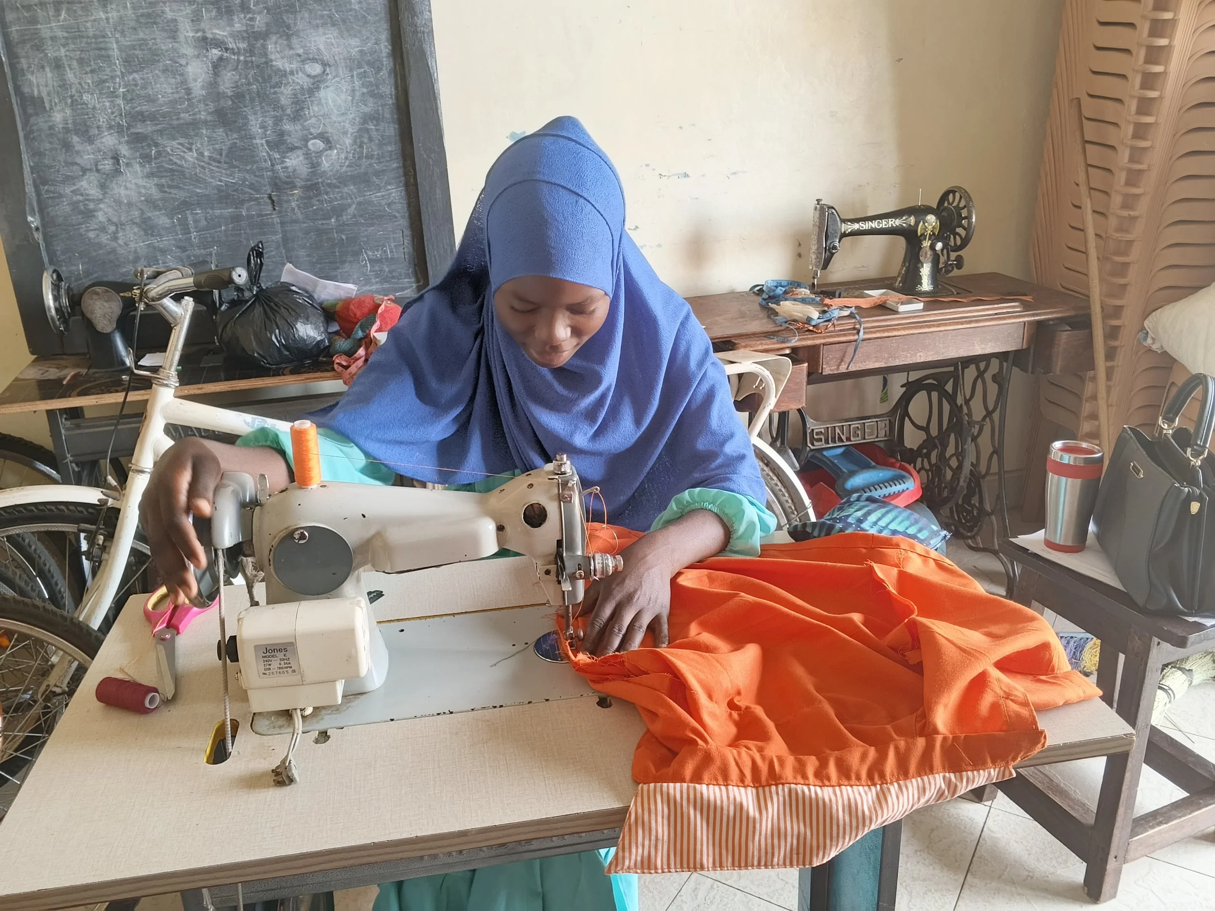 Rural woman using a sewing maching in tailoring class
