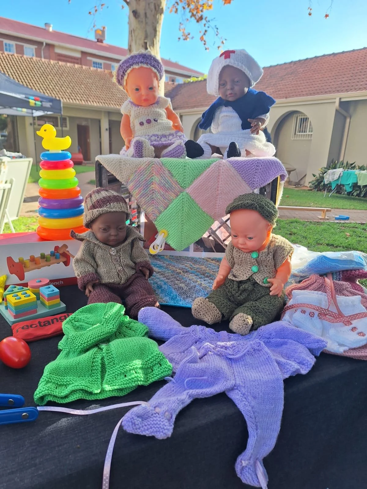 Dolls and stacking ring at outdoor event.JPG