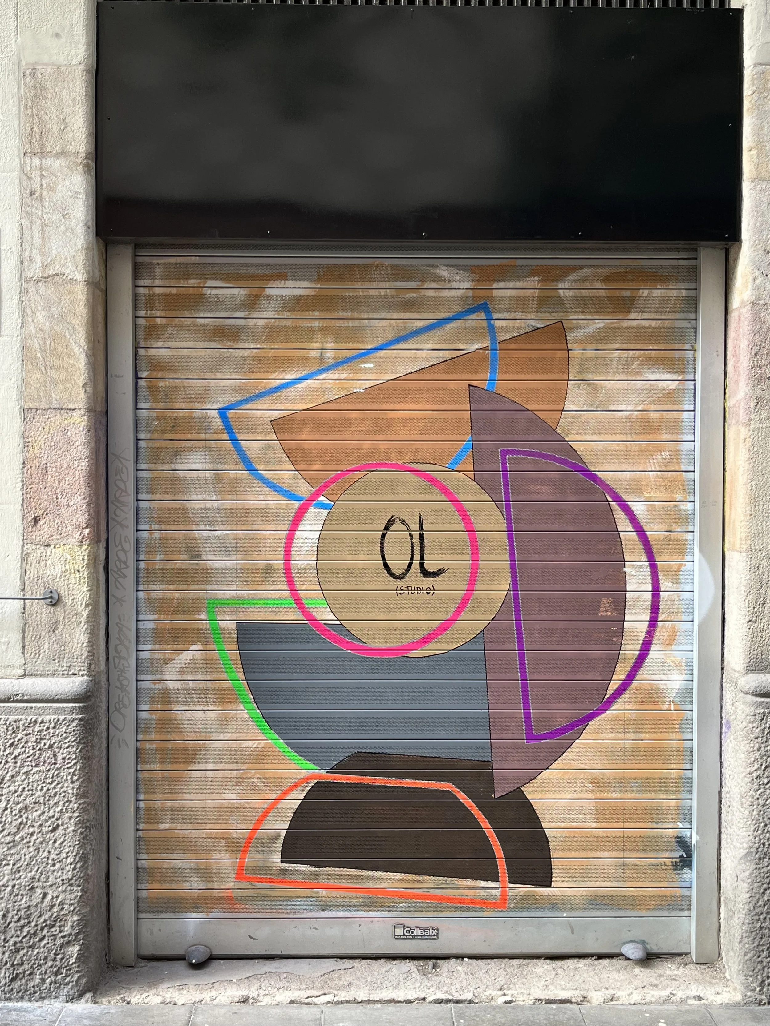 Arte urbano en una persiana metálica con formas geométricas de diferentes colores y un círculo en el centro que dice 'OL estudio'.
