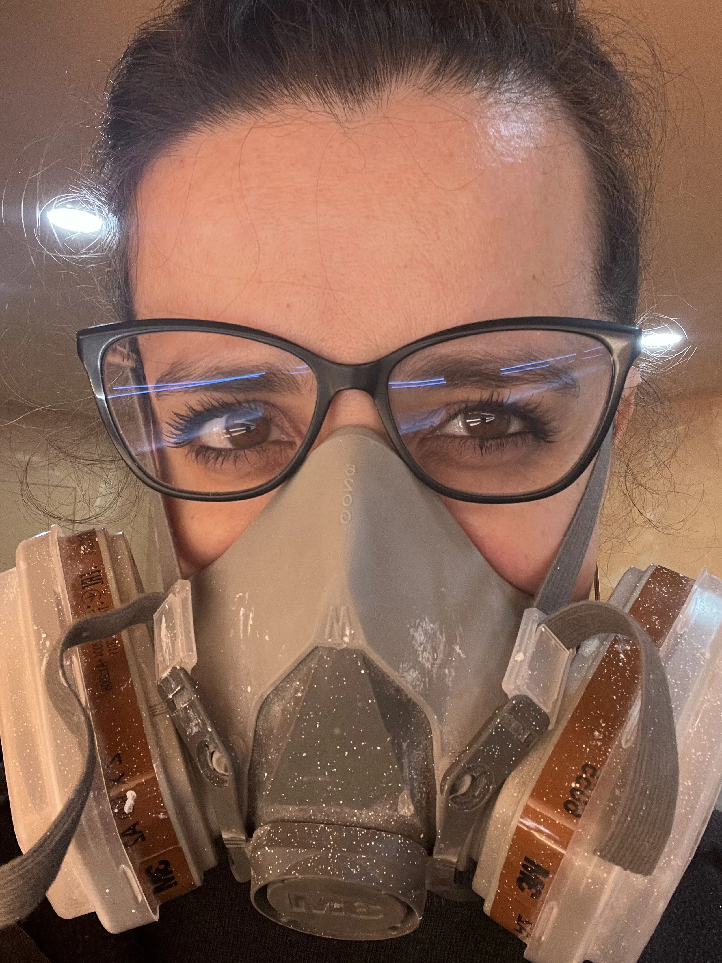 Mujer con gafas y máscara de protección, con polvo en la máscara.