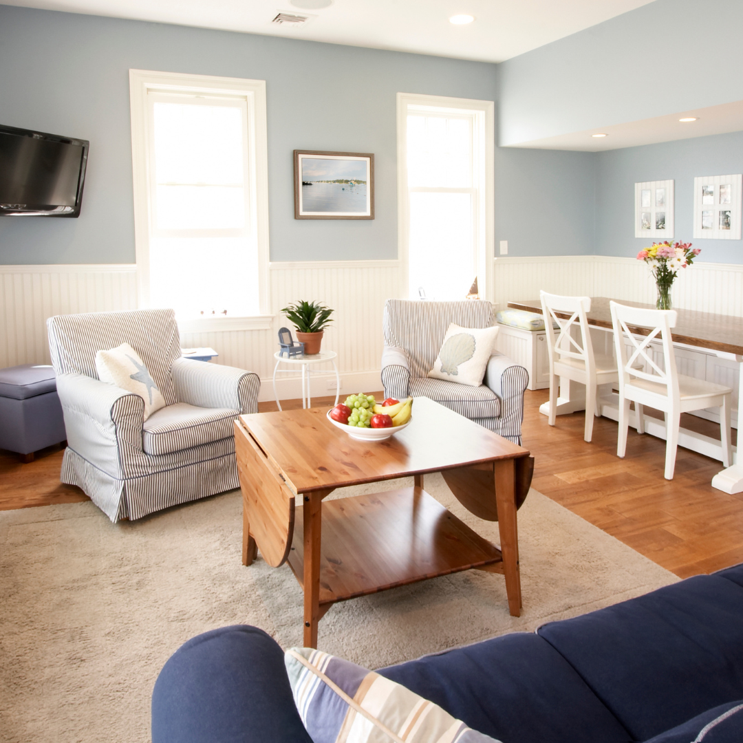 A living room with light blue walls and a mix of light, dark blue, and wooden decor colors