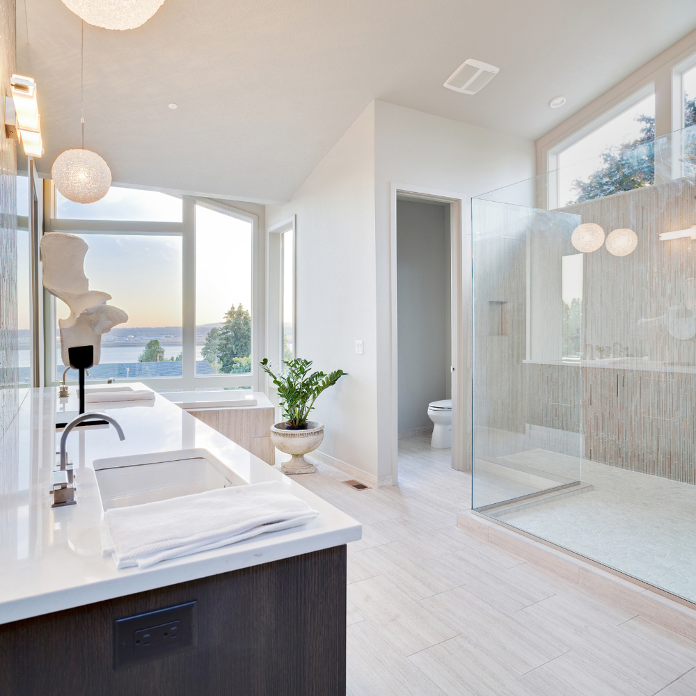 A cream-colored bathroom with light wood flooring and soft lighting