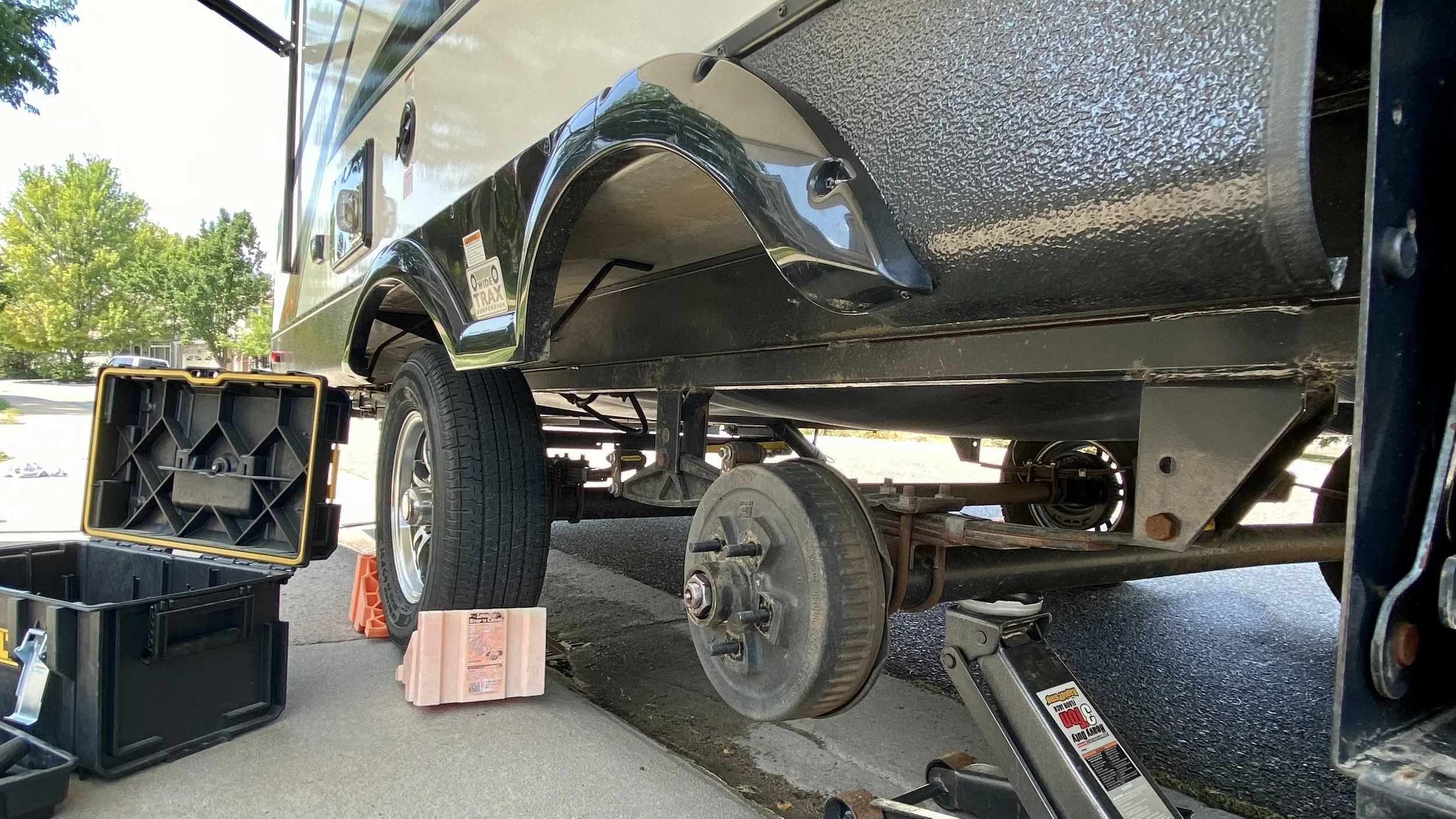 A travel trailer supported for wheel and suspension service