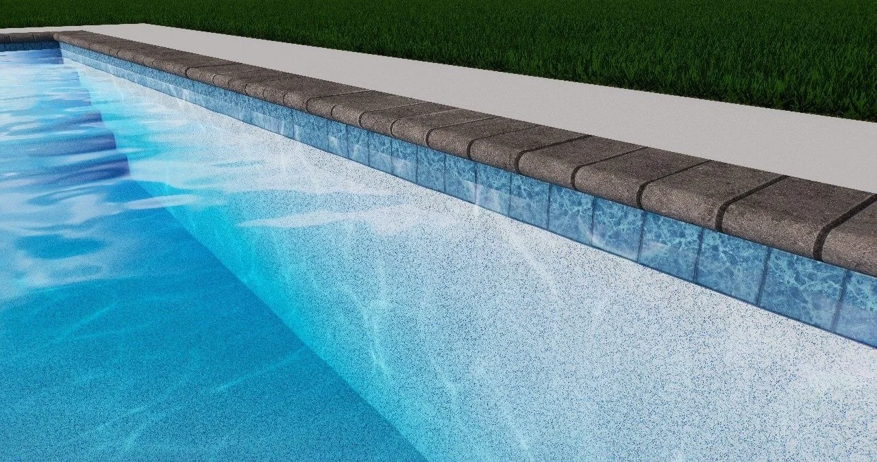 Clear blue swimming pool with stone tile edge and grass in background.