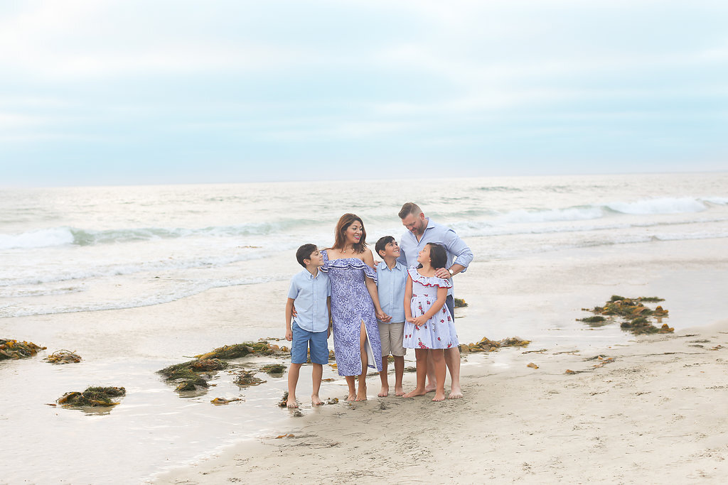 the Branco family standing on the beach together - family portraits in San Diego by Photography by L Rose