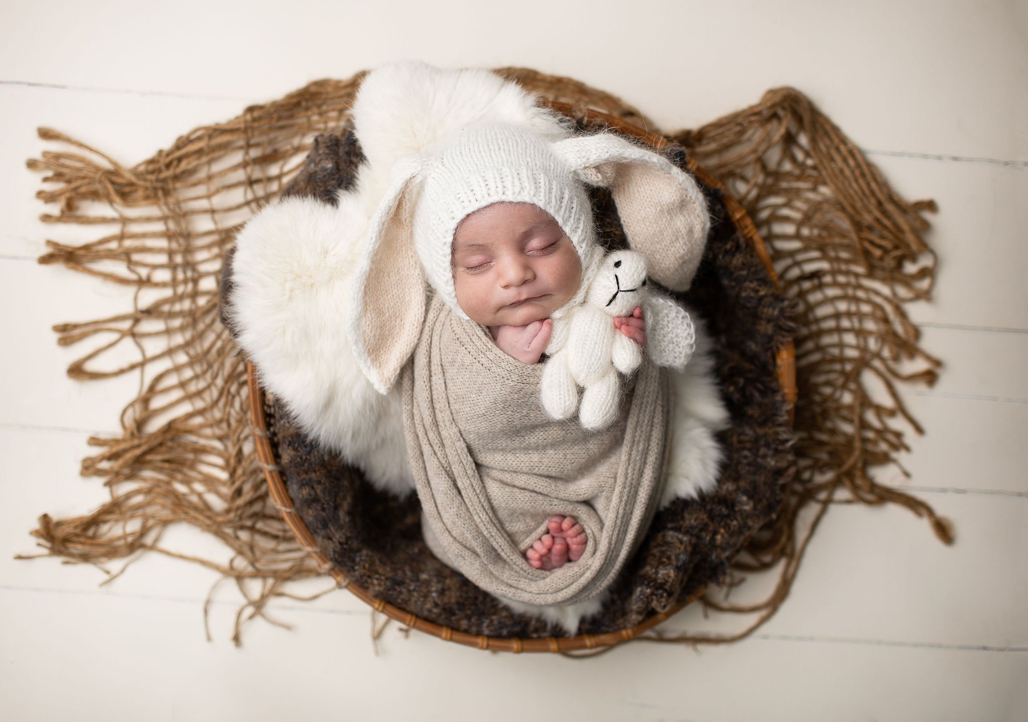  adorable baby wrapped in a brown blanket holding a tiny bunny by San Diego baby photographers 