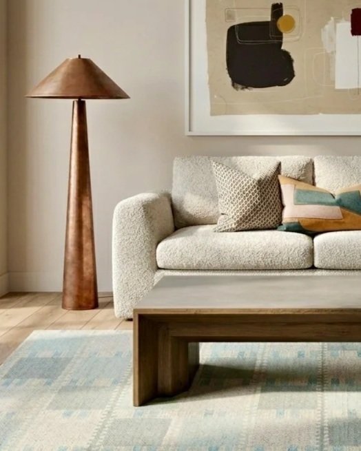 Living room with textured sofa, copper floor lamp, abstract art, and rug, home design consultation